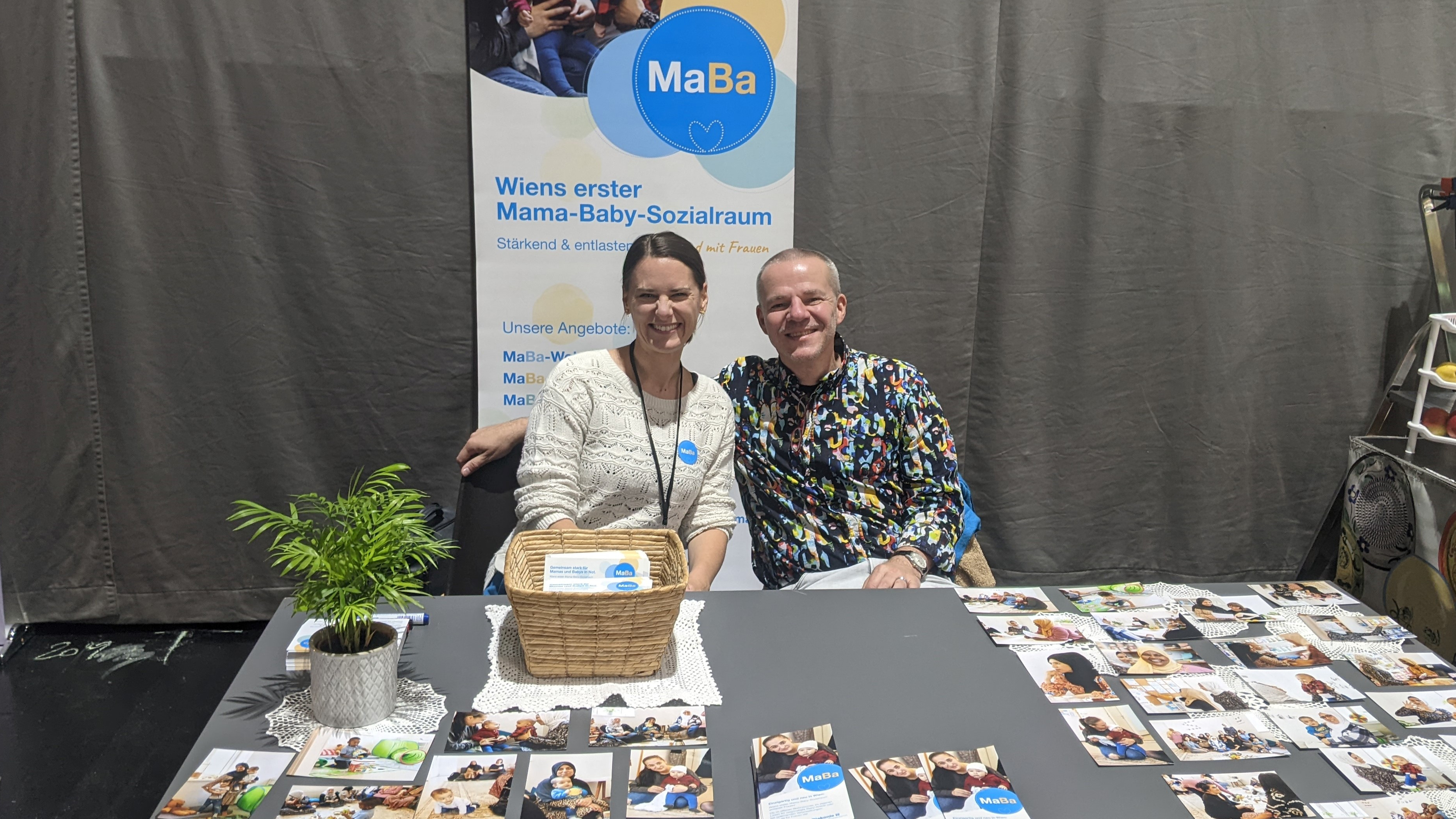 Teresa Bodner und Veranstalter Johannes Breit sitzen am MaBa-Stand und lächeln.