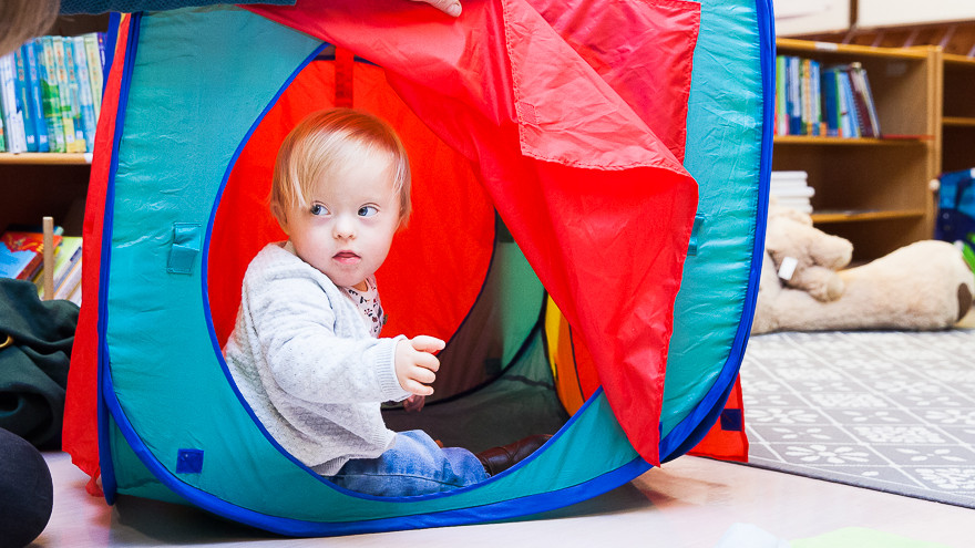 Mädchen in Spielzelt wird von ihrer Frühförderin eingeladen, heraus zu kommen.