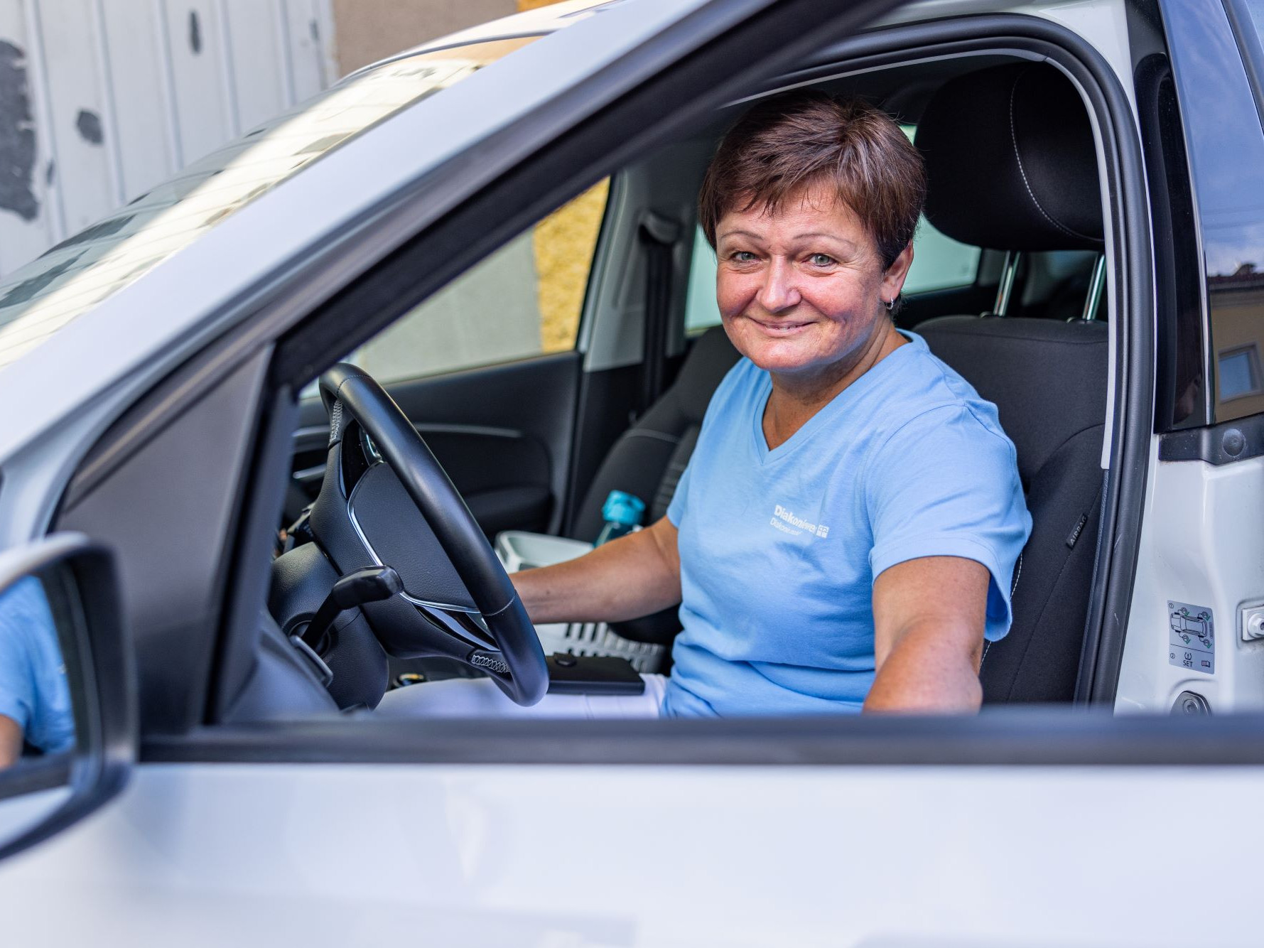 Frau in Auto zur mobilen Pflege