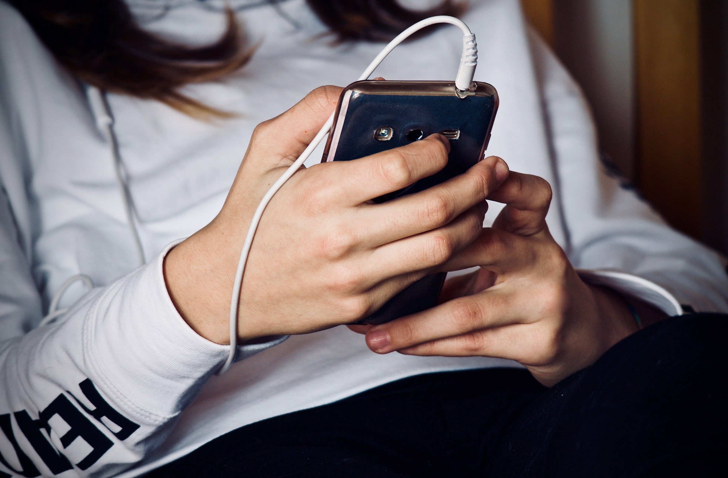 Jugendliche mit einem Mobiltelefon in Händen